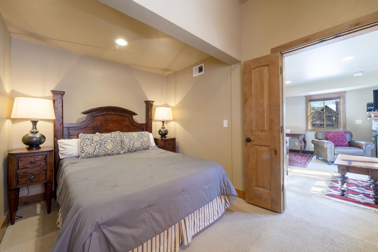 Rest easy in the comfortable queen bedroom at Jupiter Inn 10, featuring a classic wooden headboard and a peaceful atmosphere. A welcoming retreat within this Park City vacation rental.