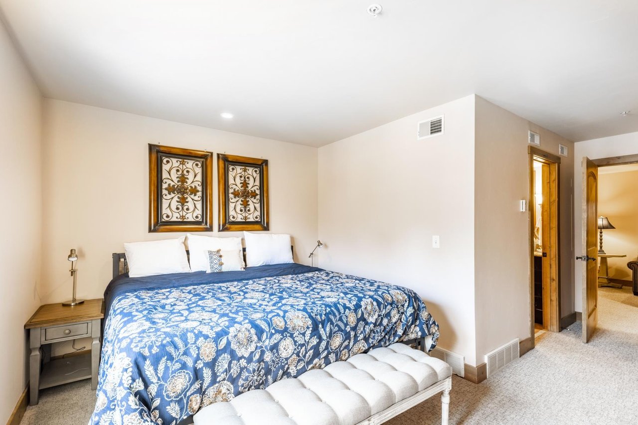 The beautifully appointed bedroom at Jupiter Inn 18 features a comfortable kingsize bed and elegant decor, offering a peaceful retreat during your Park City vacation rental stay.