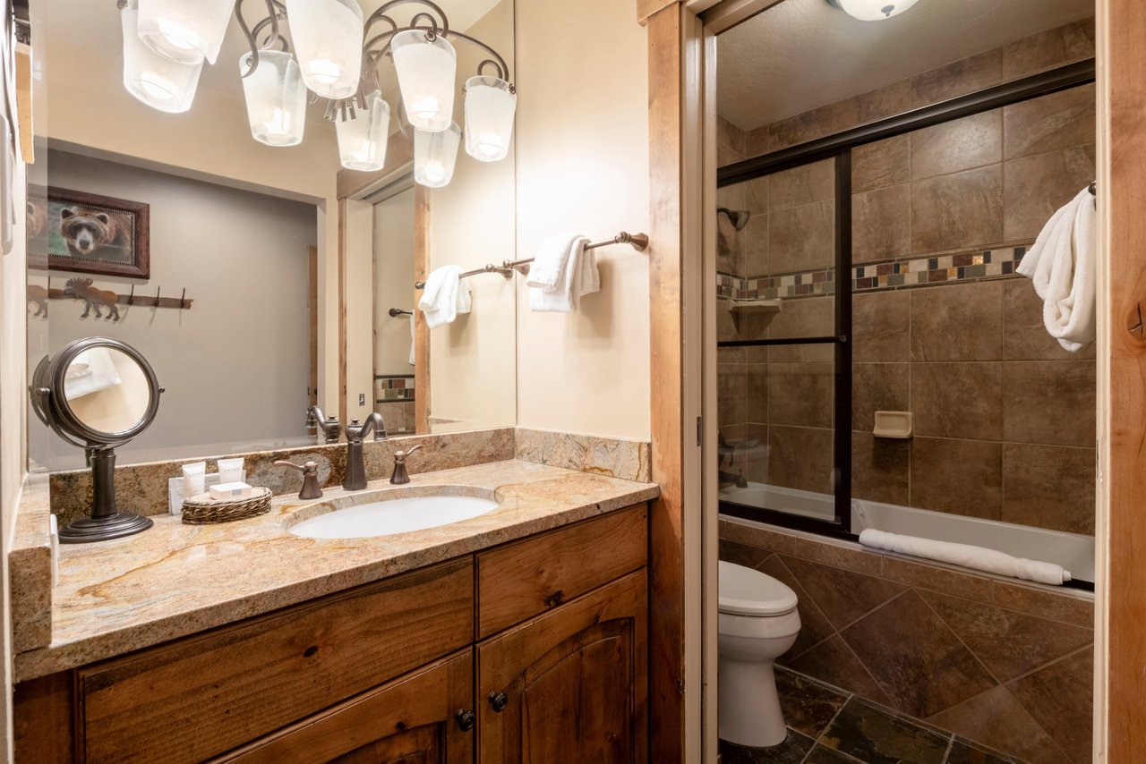 Every detail counts at Resort Plaza 5002 — this Park City vacation rental features a beautifully finished bathroom with warm wood vanity, granite countertops, and a sleek glassenclosed shower for a s