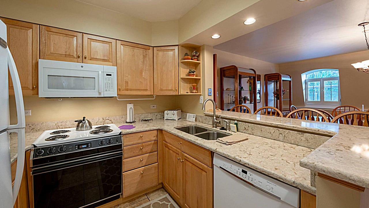 Resort Plaza 5013 makes every stay feel like home with a fully equipped kitchen featuring granite countertops and warm wood cabinetry — a perfect Park City vacation rental for any group.