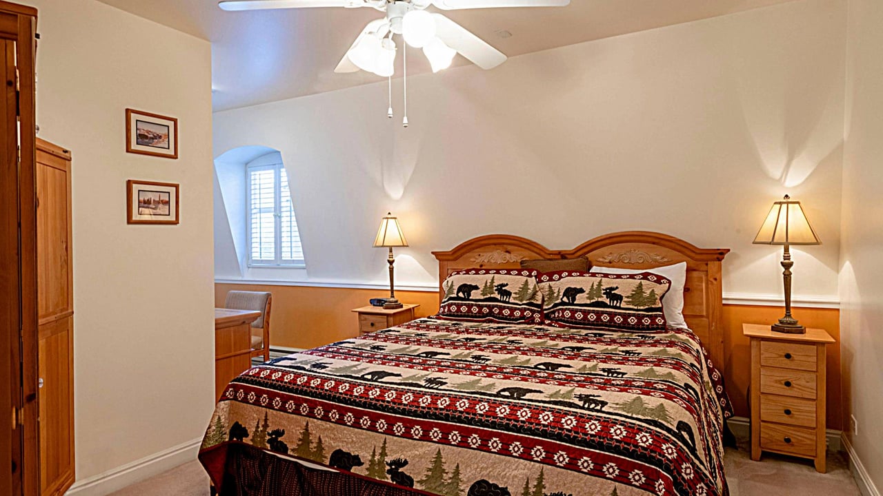 Cozy up in the charming king bedroom at Resort Plaza 5013 — a delightful Park City vacation rental featuring classic mountainthemed bedding and a warm, rustic atmosphere.