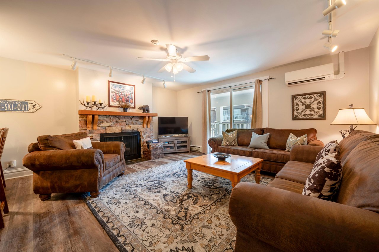 Cozy up by the fireplace in the spacious living room at Resort Plaza 5022 — a warm and inviting Park City vacation rental perfect for relaxing after a day on the slopes.