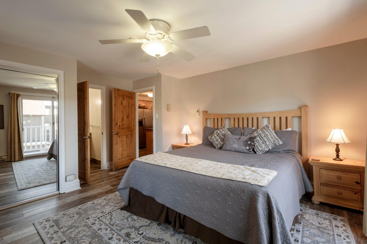 Rest and recharge in the serene king bedroom at Resort Plaza 5022 — a beautifully appointed Park City vacation rental with warm wood furnishings and a peaceful atmosphere.