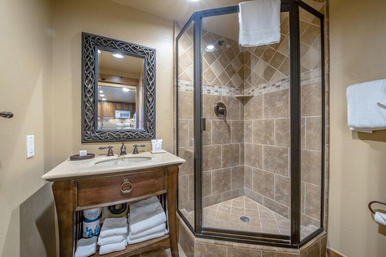 Freshen up in style in the beautifully finished bathroom at Resort Plaza 5009 — this Park City vacation rental features a elegant walkin tile shower, decorative vanity, and plush towels for a boutiqu