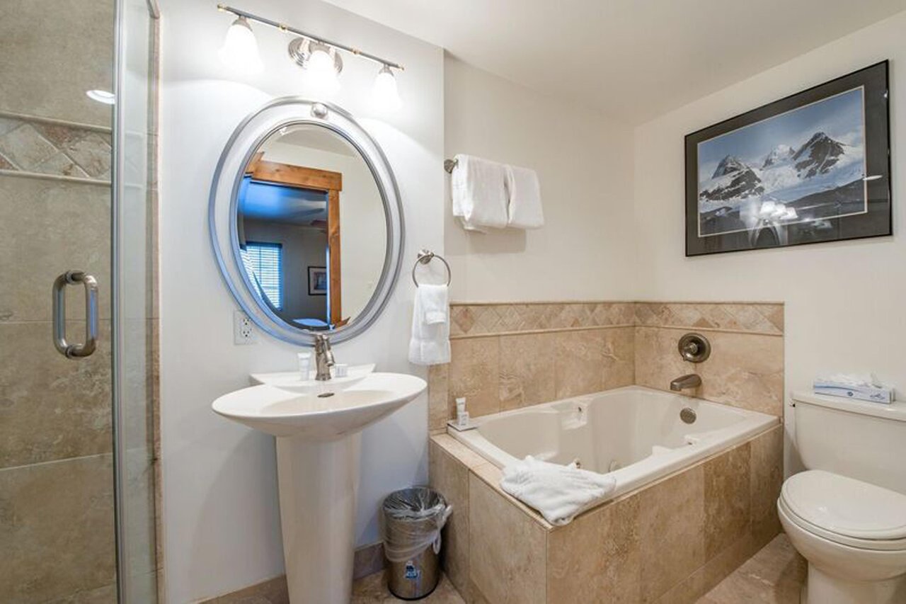 Soak your cares away in the relaxing jetted tub at Resort Plaza 5009 — this Park City vacation rental offers a serene bathroom retreat with warm tile surrounds and classic pedestal sink, perfect after