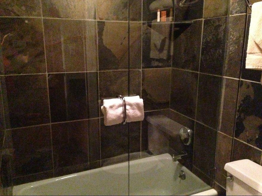 Dark dramatic tile surrounds the tub and shower at Resort Plaza 5022 — a sophisticated finishing touch in this comfortable Park City condo rental and Park City lodging option.
