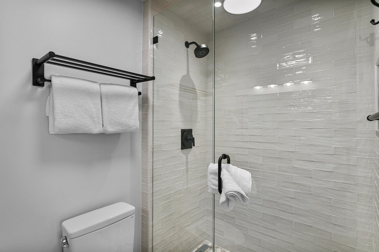 Rinse off and refresh in this beautifully tiled walkin shower, featuring sleek matte black fixtures and a clean, modern design. Spalike touches like these make this Park City vacation rental truly s