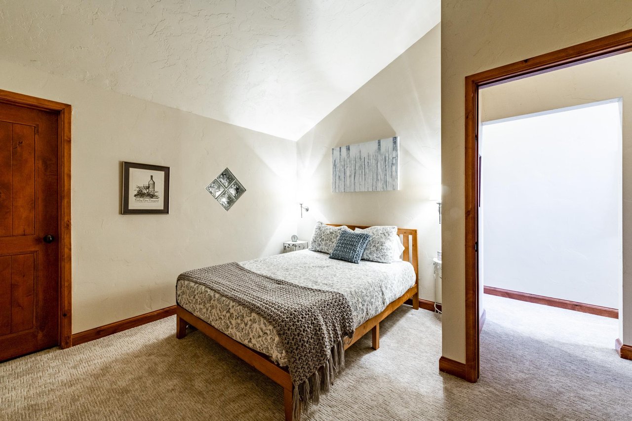 Tuck in under the vaulted ceilings of this warm and welcoming bedroom at Park Avenue 245 — a peaceful haven that makes your stay in Park City feel like a true mountain escape.
