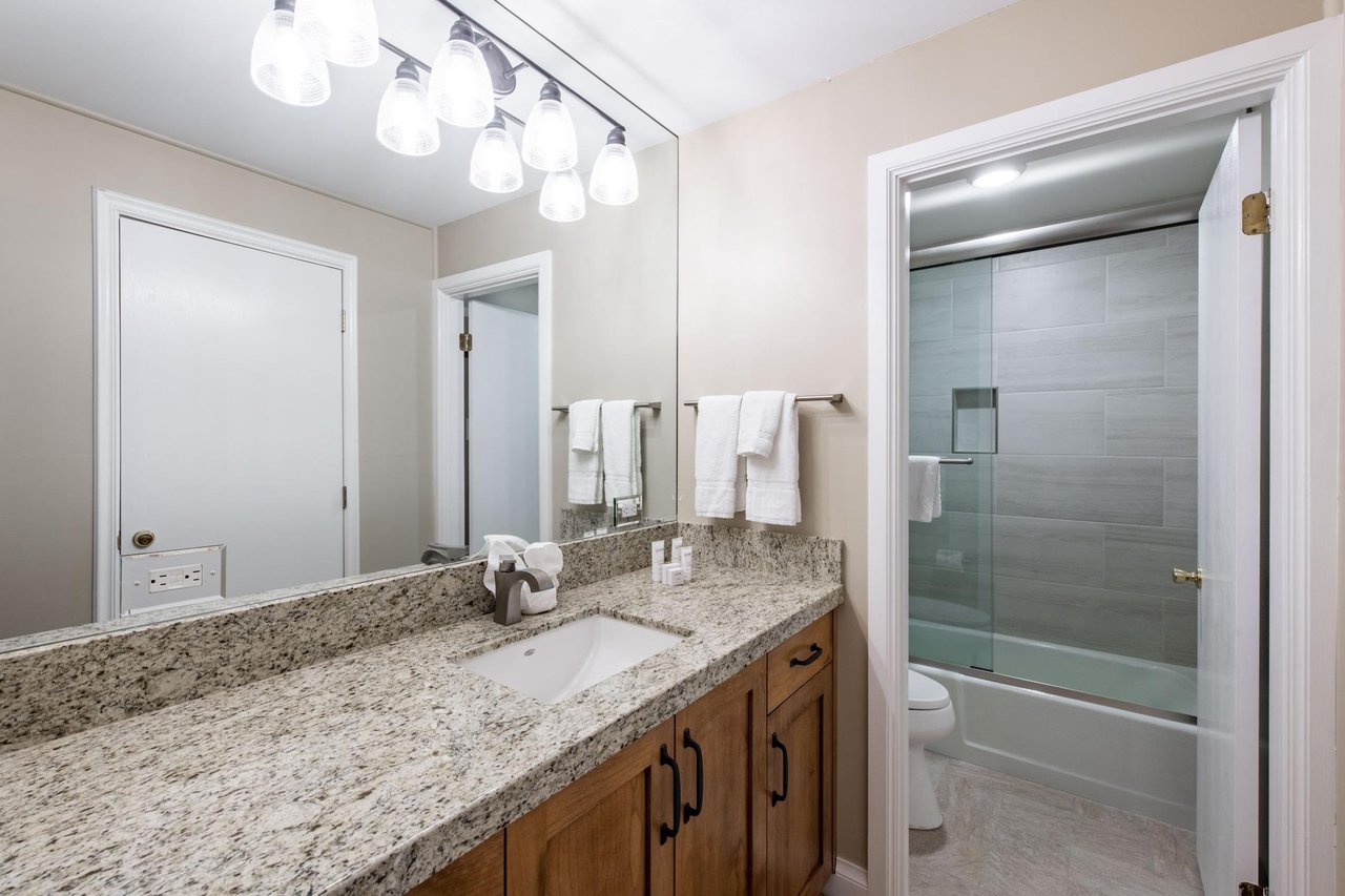 This wellappointed bathroom features a generous vanity with granite countertops and a glassenclosed shower, providing a clean and comfortable space to refresh during your Park City vacation rental s