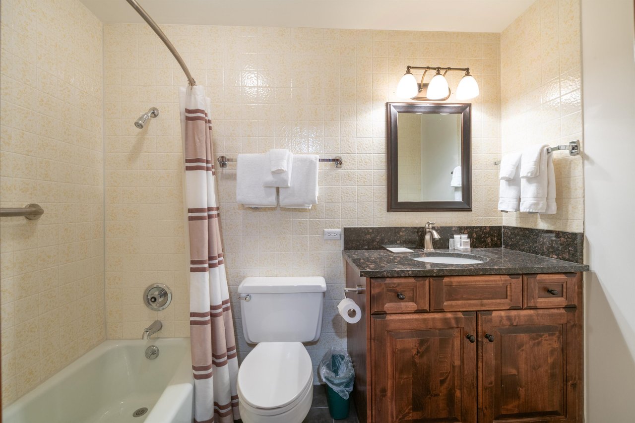 Rustic wood details and dark granite finishes give this bathroom a warm mountain character, offering all the essentials for a comfortable and convenient Park City lodging experience at Resort Plaza 50