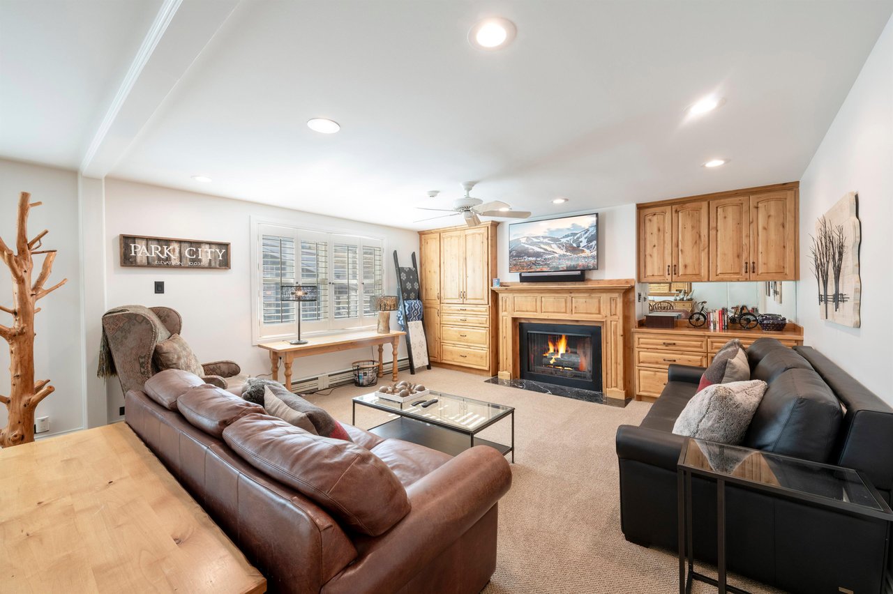 Cozy up by the warm fireplace in this inviting living room, featuring rich leather seating and classic mountaininspired wood accents throughout. The perfect retreat after a day on the slopes at this