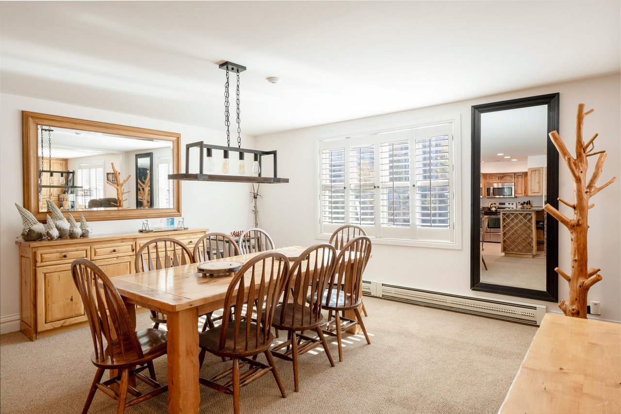 Natural wood tones, a stylish pendant light, and an open connection to the outdoors make this dining area a charming and functional space for gathering together. Resort Plaza 5034 is a wonderful choic