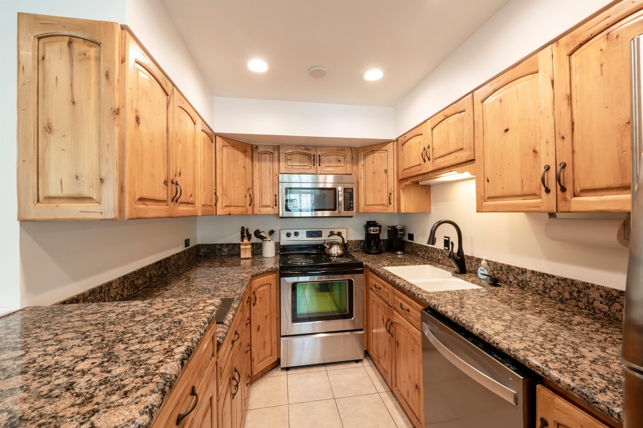 Warm wood tones, granite countertops, and a complete set of modern appliances come together in this functional and attractive kitchen. Everything you need for a comfortable and convenient Park City lo