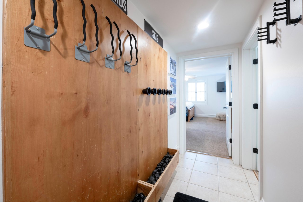 This thoughtfully designed mudroom entry features a custom wood wall with builtin hooks and a boot tray, making it the perfect space to store gear after a day on the mountain. A practical and stylish