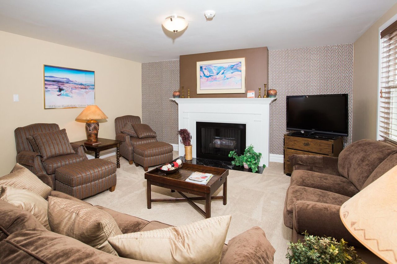 Gather around the cozy fireplace in this comfortable and welcoming living room, featuring plush seating and warm, relaxed décor perfect for unwinding after a day on the mountain. A true home away from