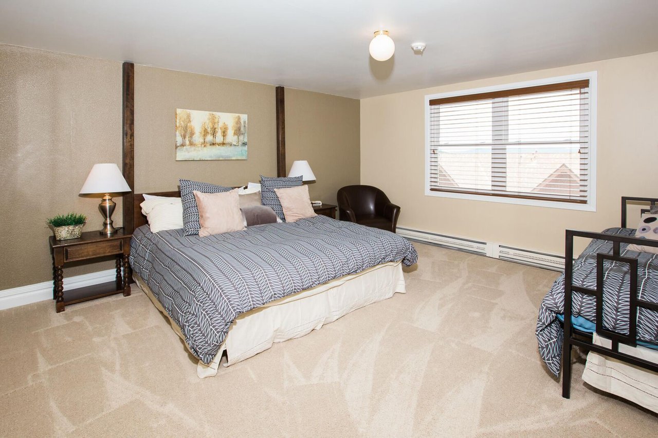 This spacious and serene primary bedroom features a king bed, warm neutral tones, and plenty of room to unwind after a day of mountain adventures. A peaceful and comfortable retreat within this Park C