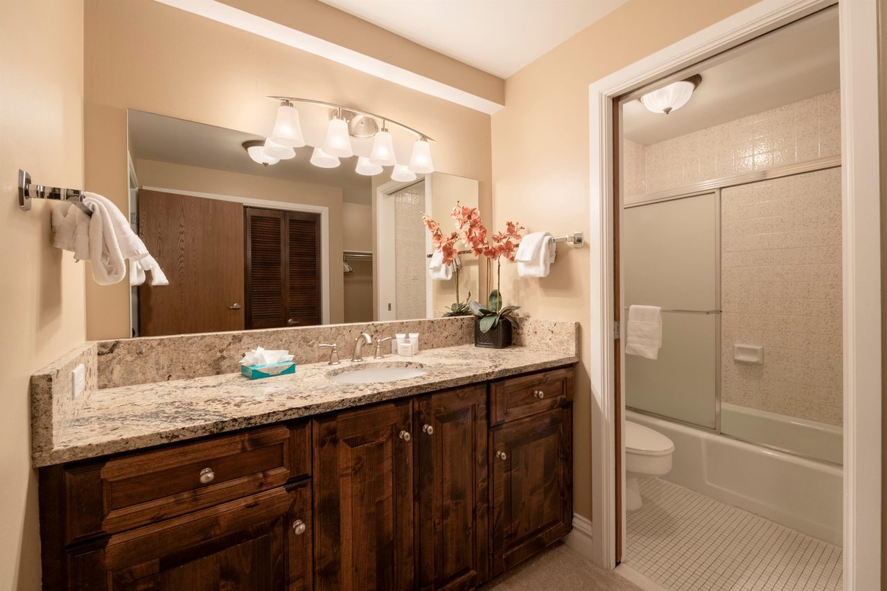 Warm wood finishes, granite countertops, and a beautifully tiled shower enclosure come together to create a refined and inviting bathroom experience. Thoughtful details like these make Resort Plaza 50