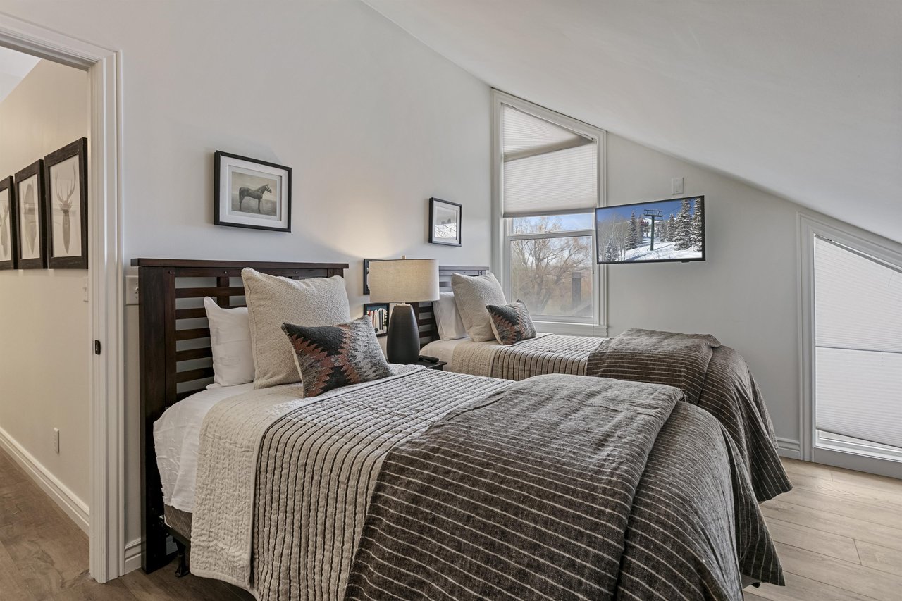 Relax in your cozy retreat with two plush beds and natural light streaming through large windows. The crisp linens and peaceful decor create a restful escape.