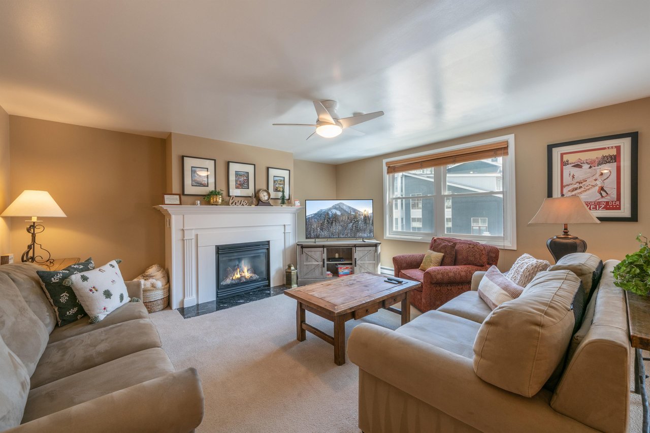 Settle in and unwind by the fireplace in the warm and inviting living room at Resort Plaza 5064, a charming Park City vacation rental that offers all the comforts of home with the beauty of the mounta