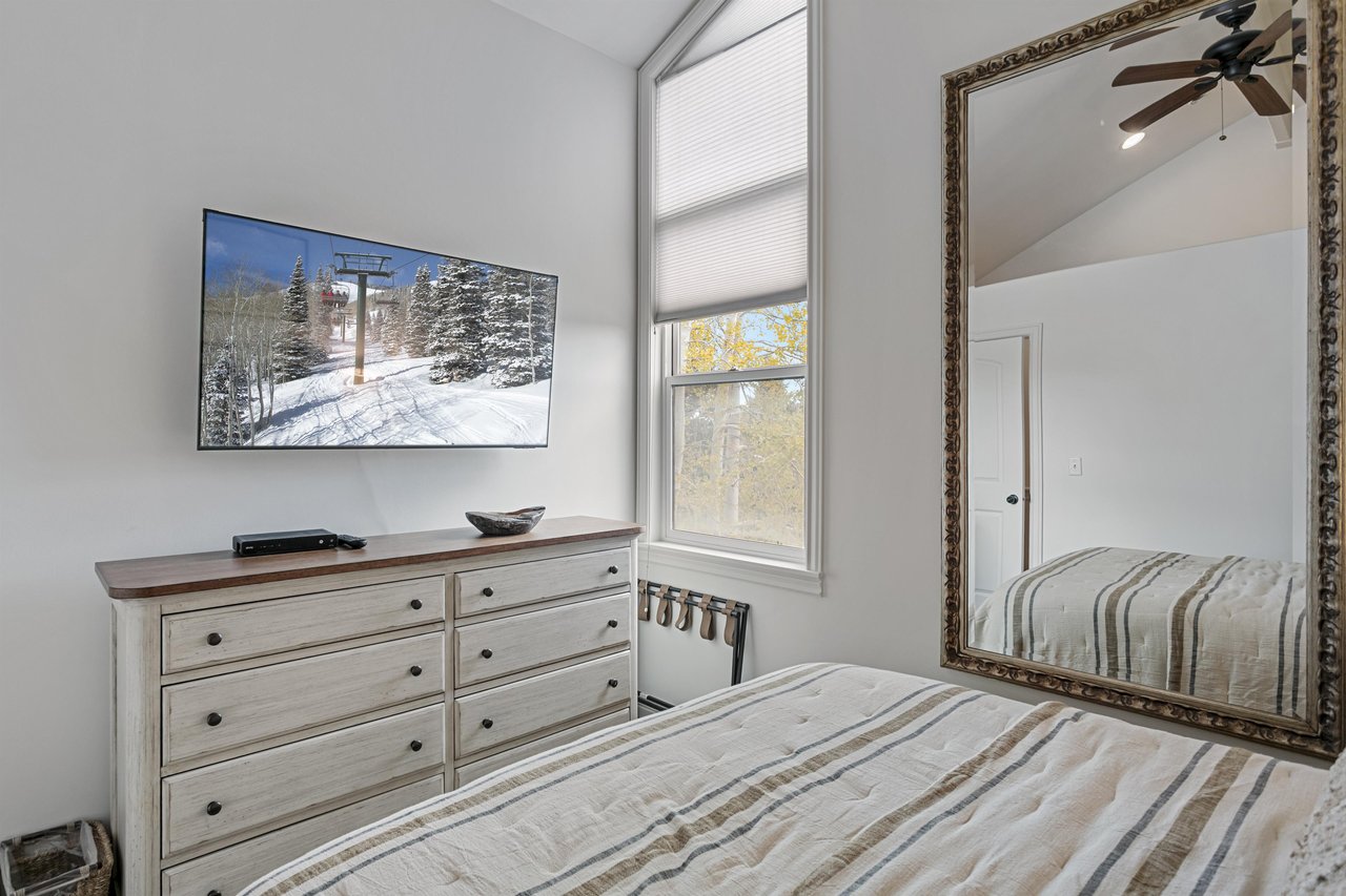 Wake up refreshed at Three Kings 83 — the remodeled bedroom includes a mounted flatscreen, generous dresser space, and abundant natural light.