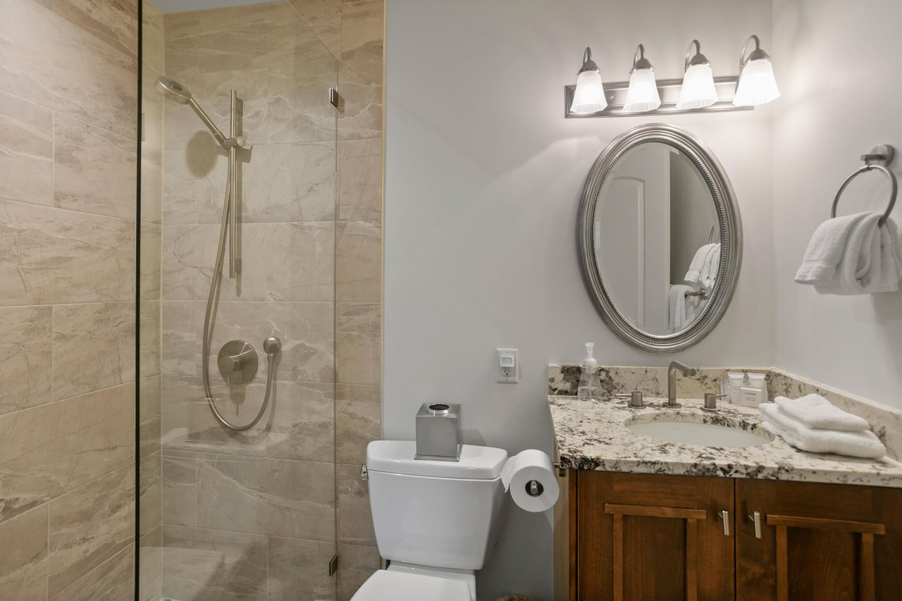 Three Kings 64 continues to impress with a stunning bathroom featuring a gorgeous walkin tile shower, warm wooden cabinetry, and granite countertops that bring a fresh and luxurious feel to this exce
