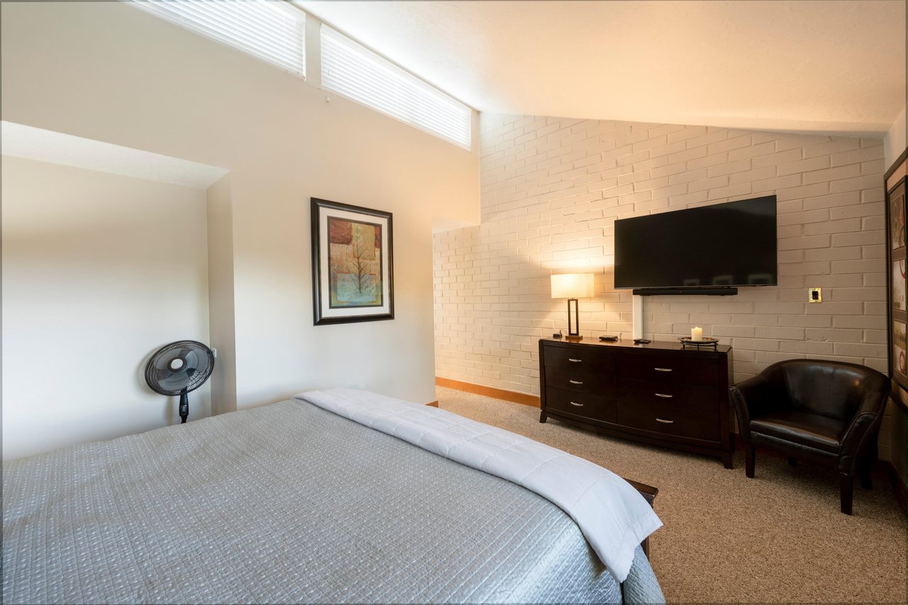 Unwind in the bright and airy bedroom at Park Avenue 256, where understated modern design and vaulted ceilings create a calm and comfortable haven.