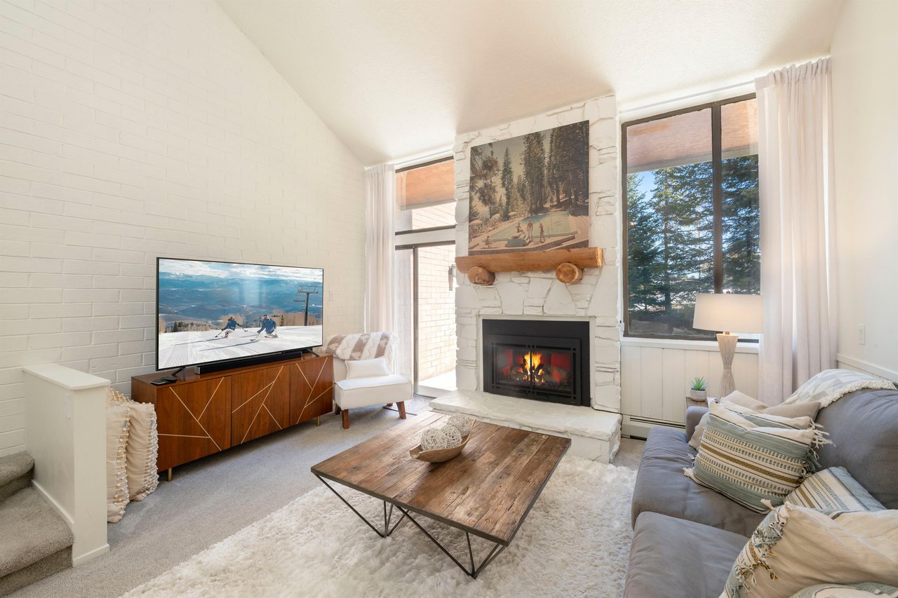 Warm tones, a glowing fireplace, and sweeping natural light make this living space at Park Avenue 299 the ultimate mountain retreat.