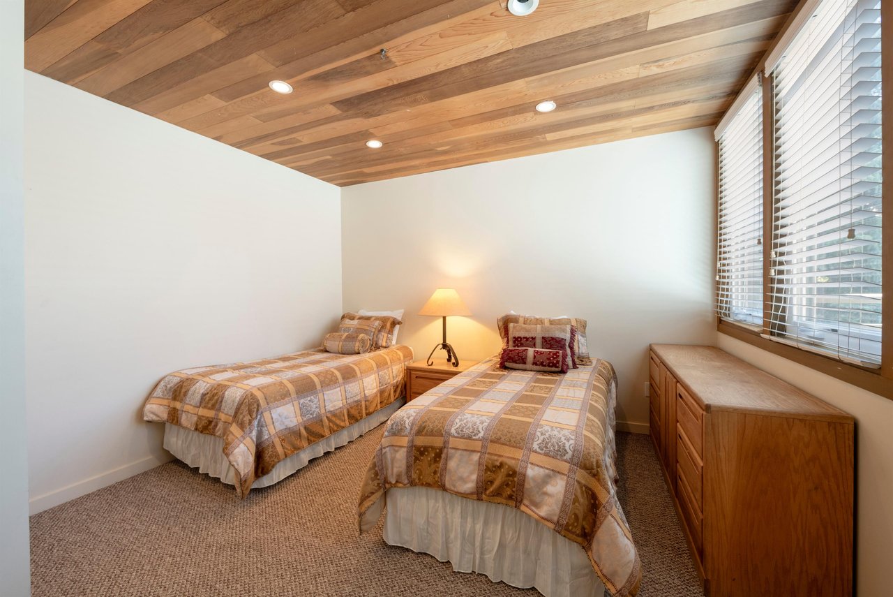 Perfect for the kids or extra guests — this charming twin bedroom at Pay Day 189 features gorgeous woodpaneled ceilings and a warm, cozy atmosphere.