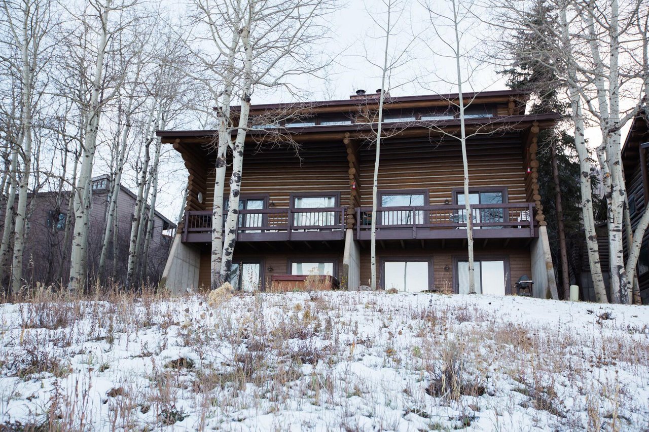 Dusted in fresh winter snow and framed by bare aspen trees, Temptation 8 is a cozy Park City vacation rental that embodies the magic of a true mountain lodge experience in the heart of ski country.
