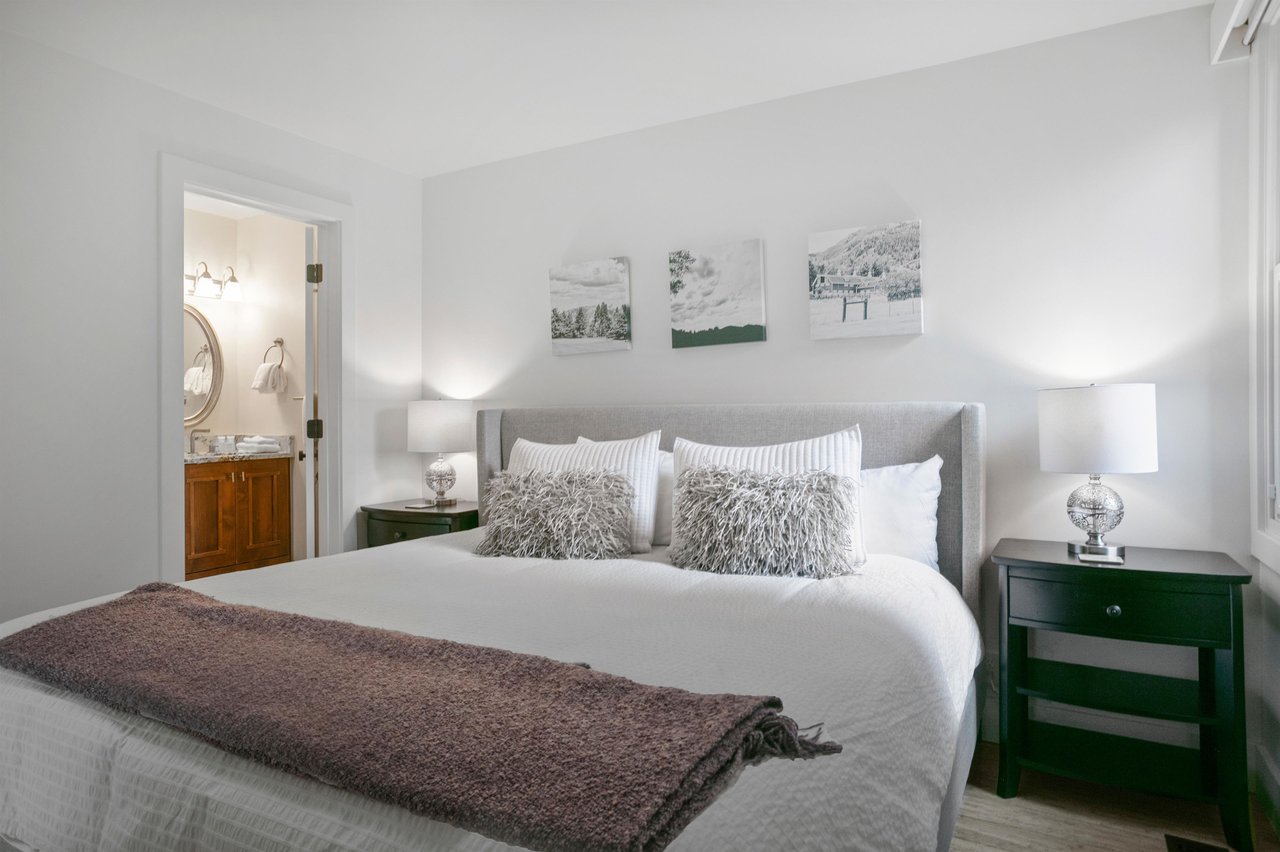 Rest and recharge in style in the elegant king bedroom at Three Kings 64, where plush bedding, tasteful artwork, and a serene neutral palette combine to offer a truly restful experience in this premie