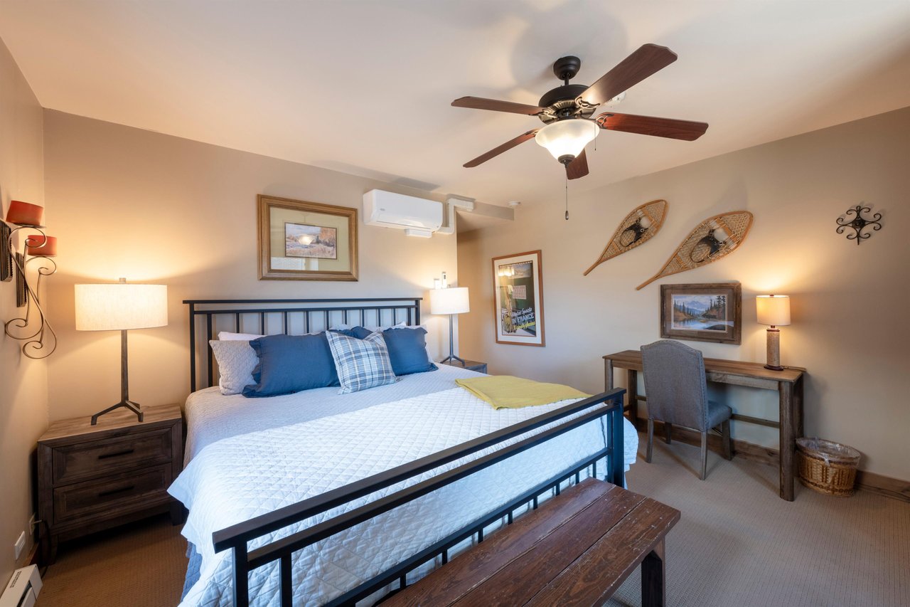 Rest and recharge in the beautifully styled primary bedroom at Resort Plaza 5002 — this Park City vacation rental offers a cozy retreat with charming mountain décor, a classic iron bed frame, and all