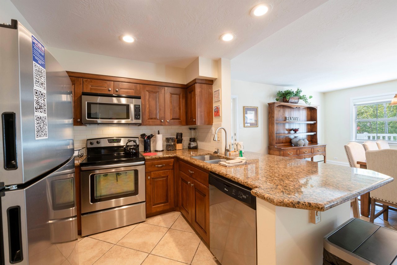 Resort Plaza 5004 features a fully equipped kitchen with stainless steel appliances, granite countertops, and warm wood cabinetry.