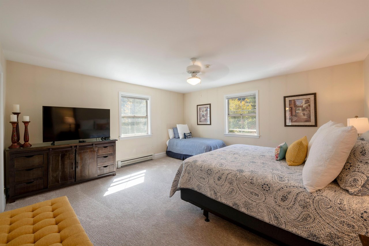 Resort Plaza 5004 has plenty of room for everyone — this bright and spacious guest bedroom features two beds, a large flatscreen TV, and beautiful natural light, perfect for families and groups.