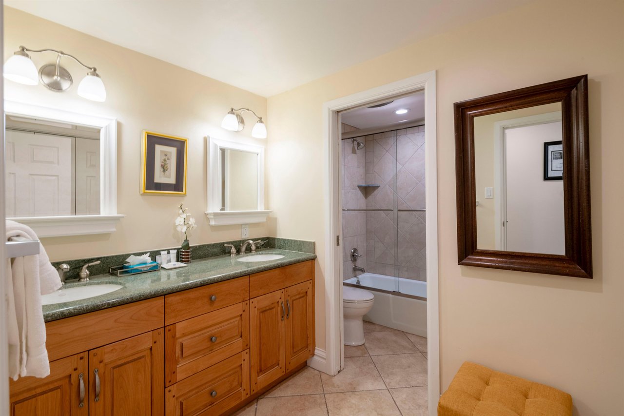 Freshen up in the spacious primary bathroom at Resort Plaza 5004 — this space features a double vanity, warm wood cabinetry, and a beautifully tiled walkin shower for a refreshing spalike experience