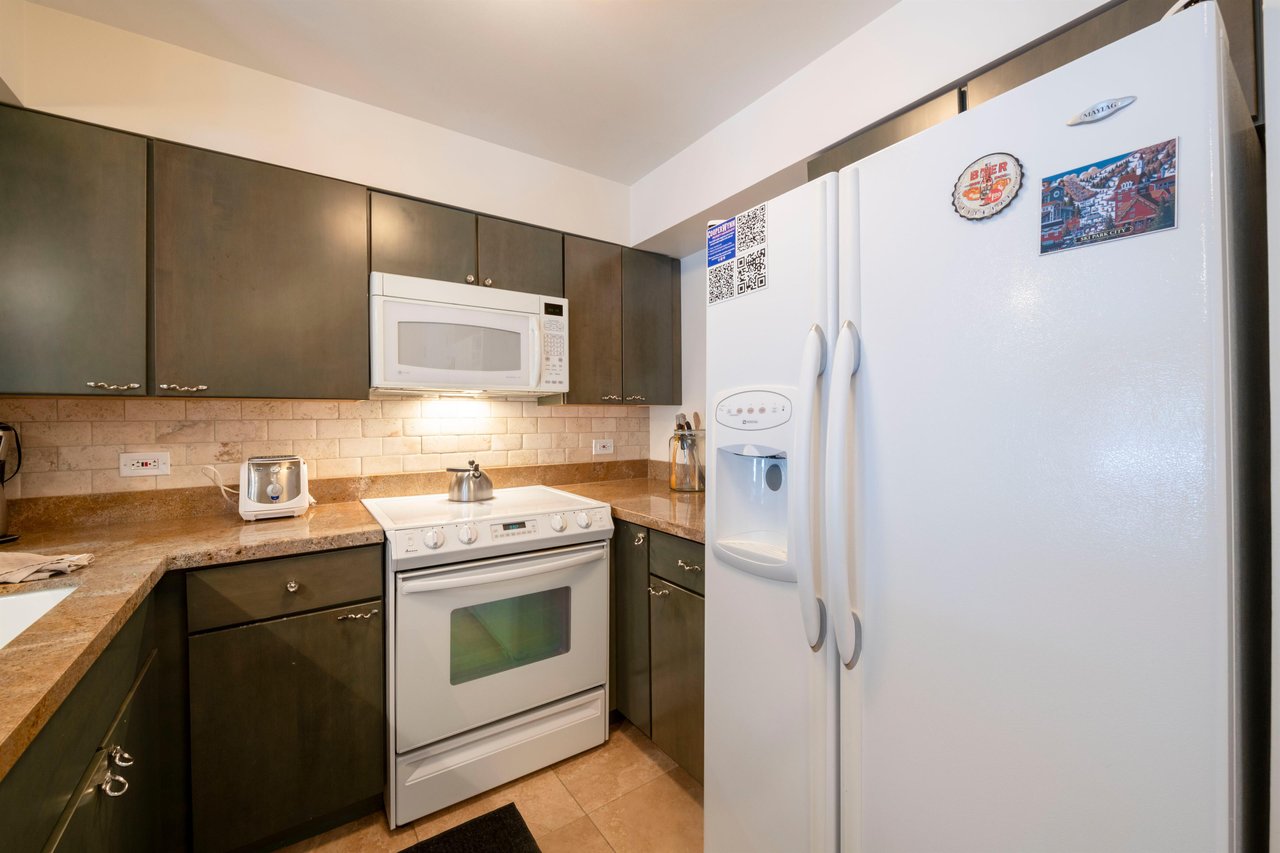 Fully stocked and ready for your stay — the efficient kitchen at Resort Plaza 5007 features fullsize appliances, rich dark cabinetry, and everything you need to prepare meals throughout your Park Cit