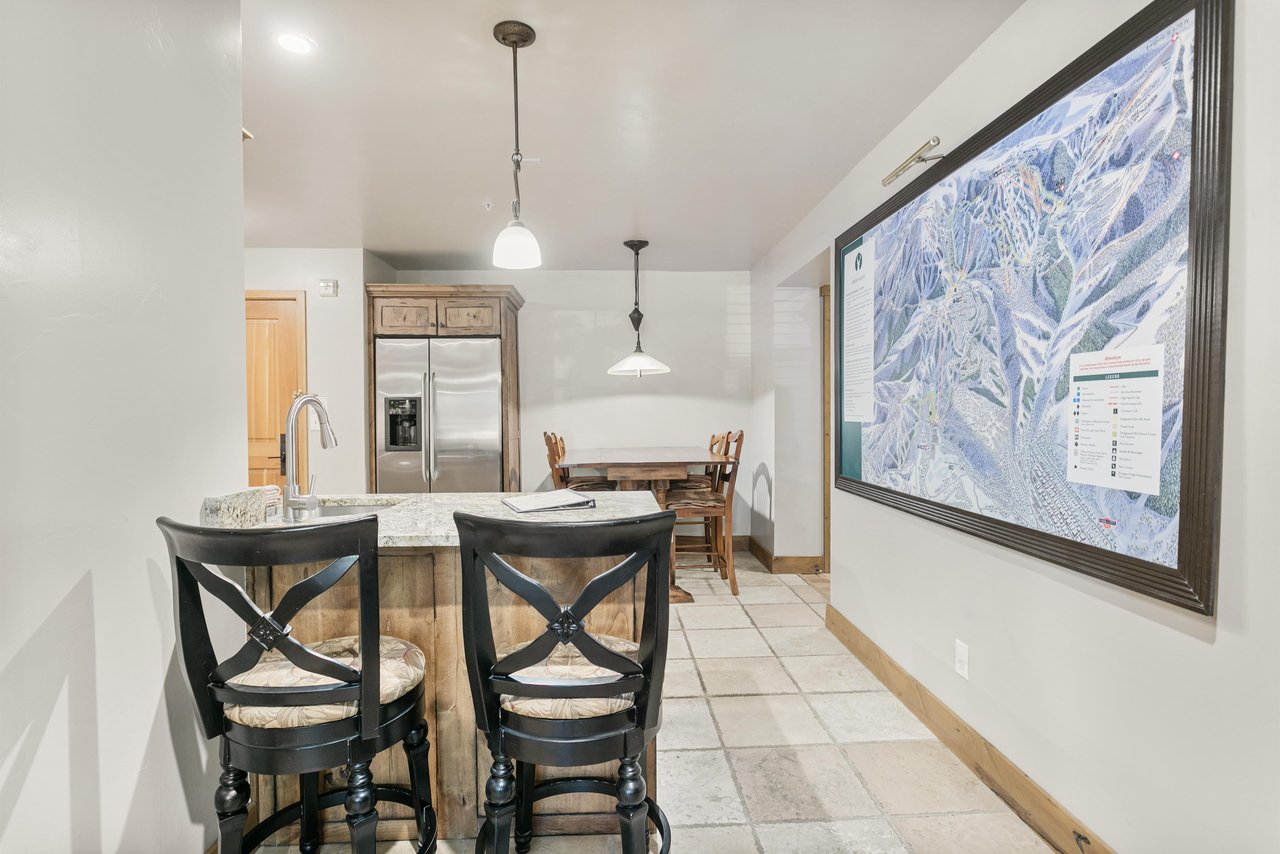 The kitchen and dining area share an open layout with a granite breakfast bar and plenty of natural light — great for morning coffee or a meal in.