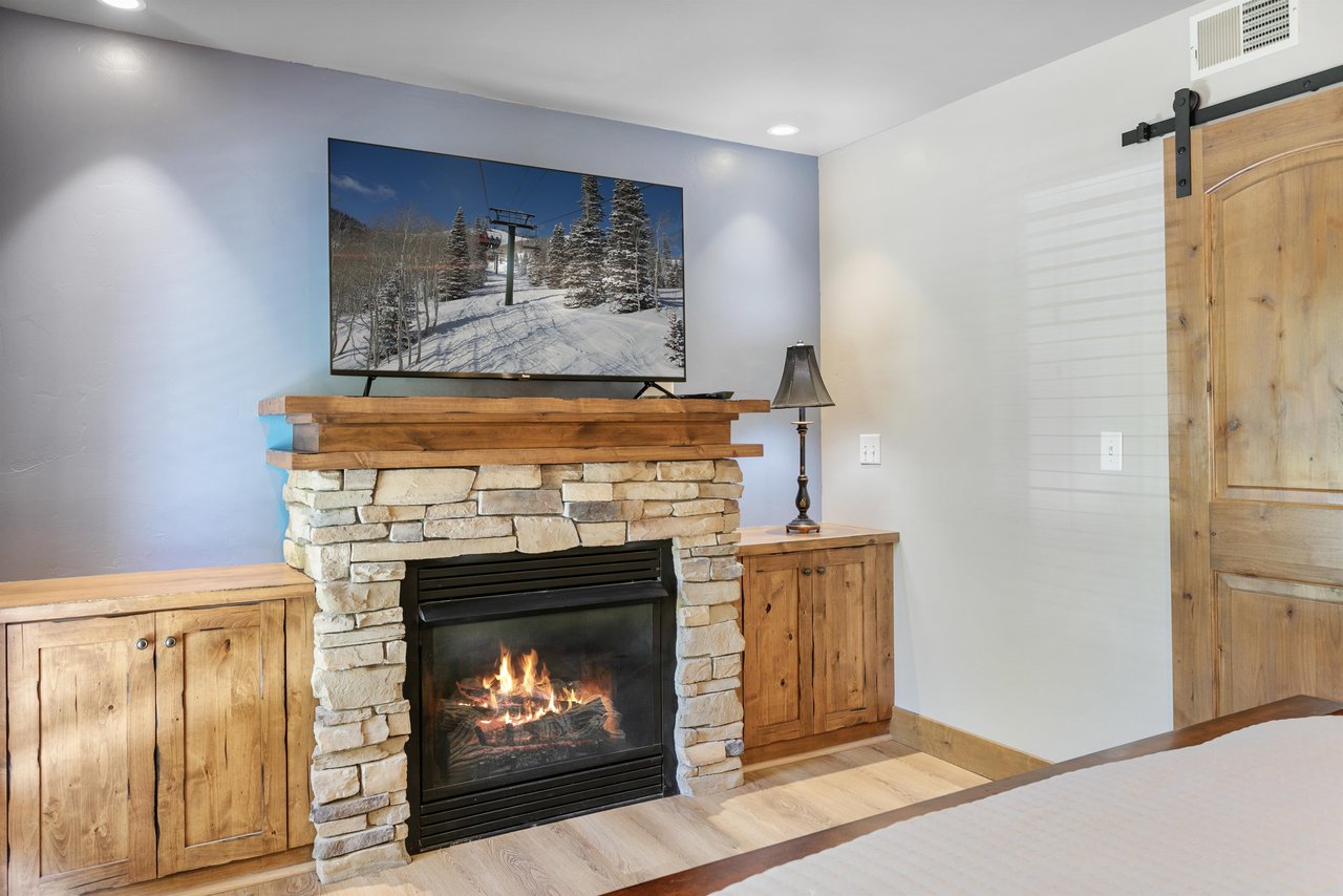 Curl up by the stone fireplace with the TV on and the slopes just outside — one of the cozier spots in this Park City condominium.