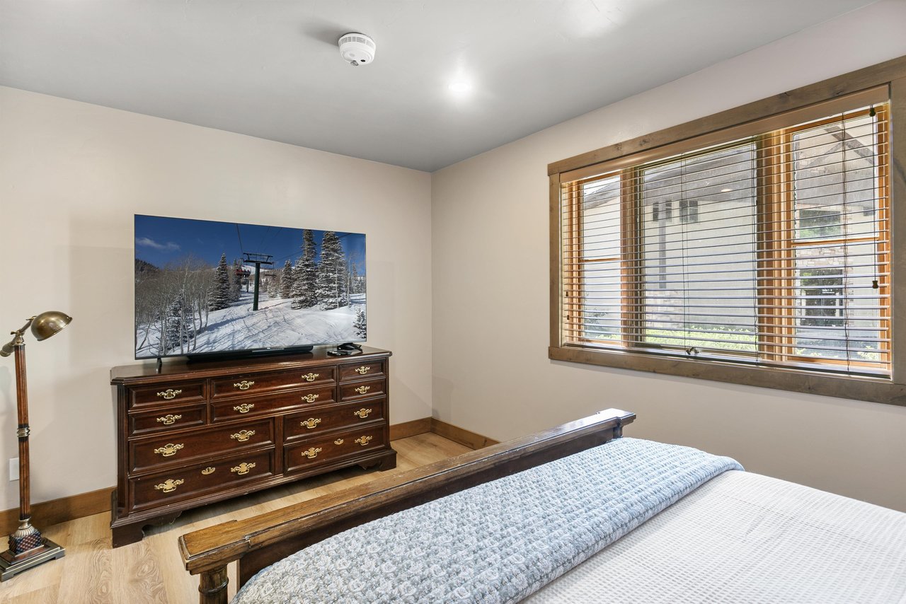 A straightforward, welllit bedroom with a flat screen TV and wooden blinds — exactly what you need for a good nights rest.