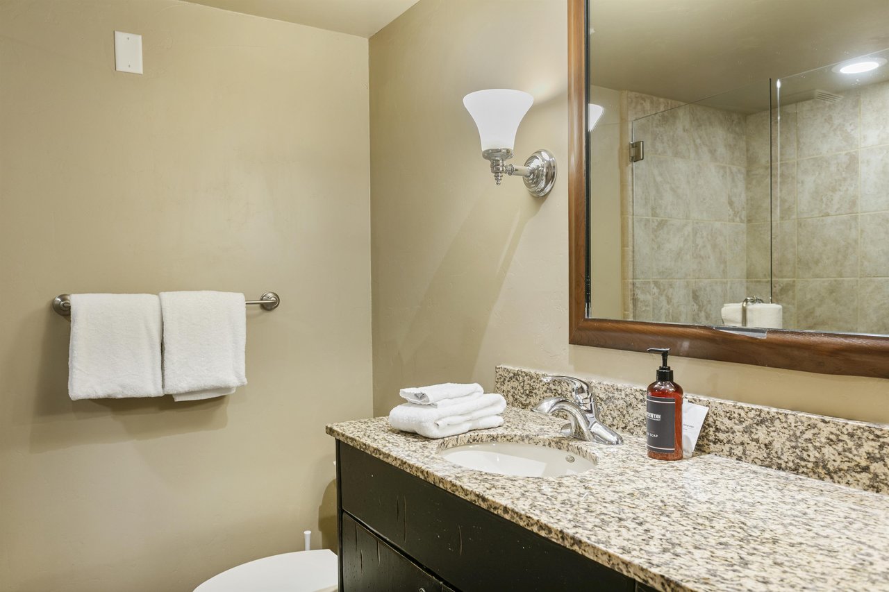 Your bathroom features a spacious granite vanity, fresh towels, elegant wall sconces, and a tiled walkin shower—everything you need to unwind after a day of adventure.