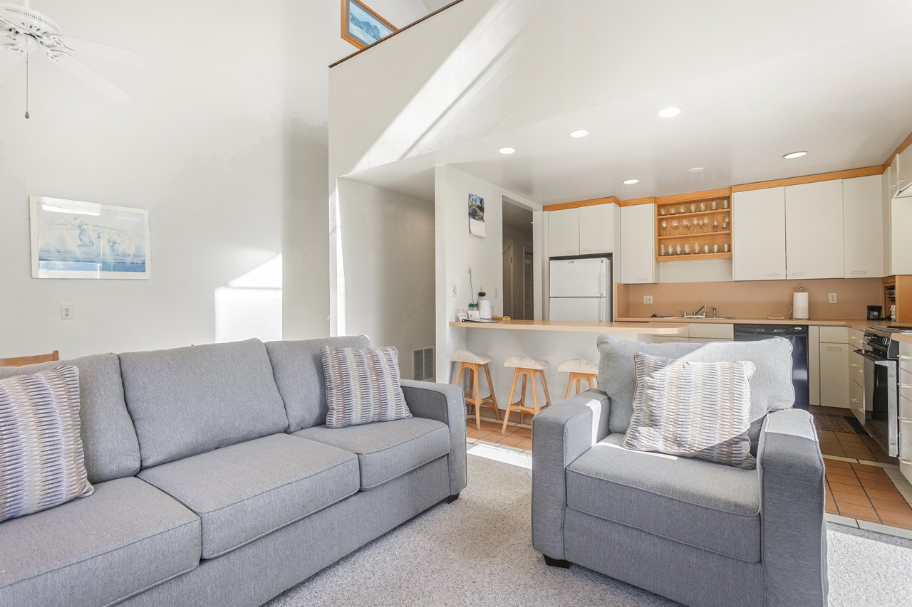 Settle into your lightfilled living space where comfortable seating flows into a fullyequipped kitchen—perfect for unwinding after exploring or preparing meals together.