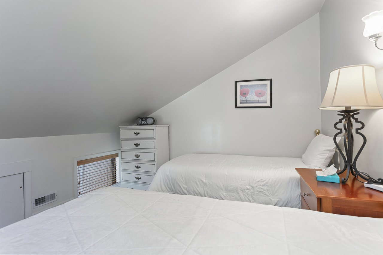Cozy twin bedroom with sloped ceilings and soft lighting—your peaceful retreat after a day of exploring, with room to unwind and recharge.