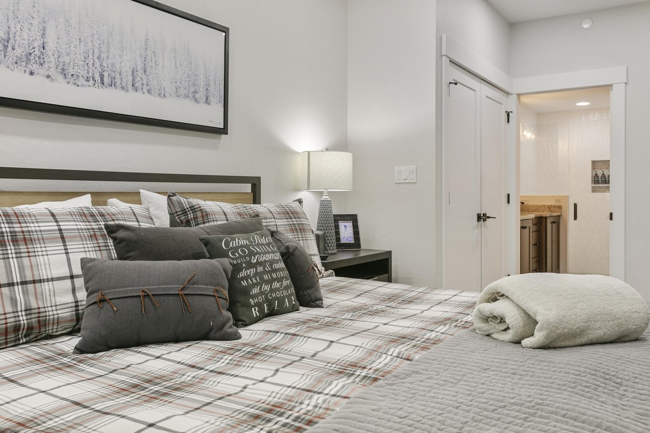 Sink into plush plaid bedding and rustic charm after a day of adventure. Your cozy retreat features soft linens, thoughtful décor, and a private ensuite just steps away.