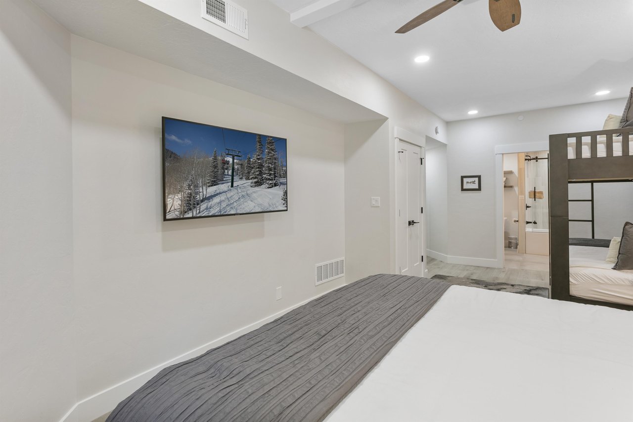 Slip into crisp linens and unwind in your bright, modern bedroom featuring mountaininspired artwork and an ensuite bathroom for ultimate comfort and convenience.