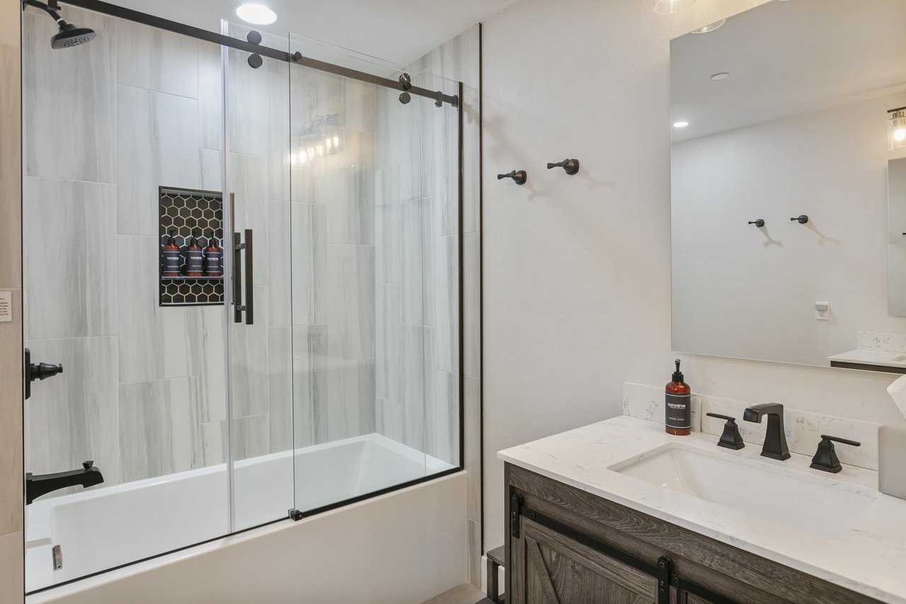 Unwind in your modern bathroom featuring sleek fixtures, marblestyle tile, and a spacious showertub combo where you can relax after a day of adventure.