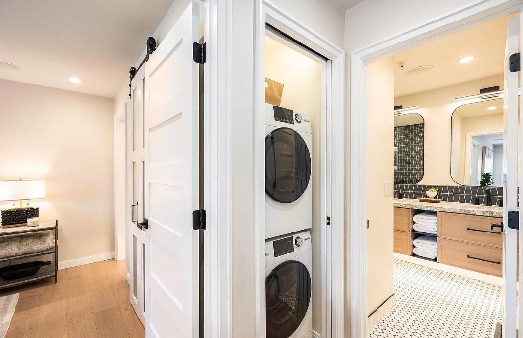 Your laundry stays effortless with a stacked washer and dryer tucked neatly behind sleek barn doors—vacation convenience without sacrificing style.