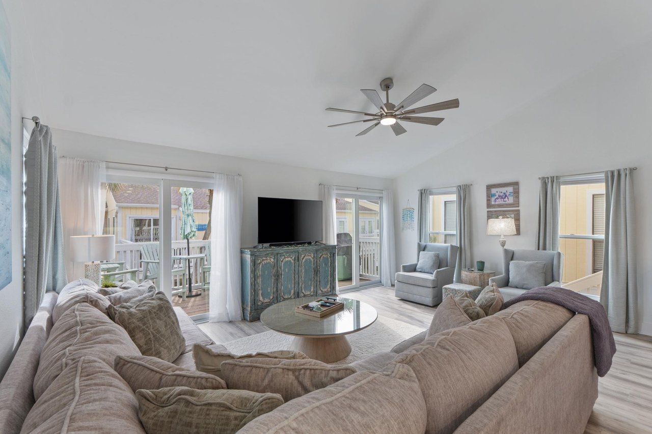 Sink into plush sectional seating where coastal breezes flow through your bright living space, perfect for relaxing after beach days.