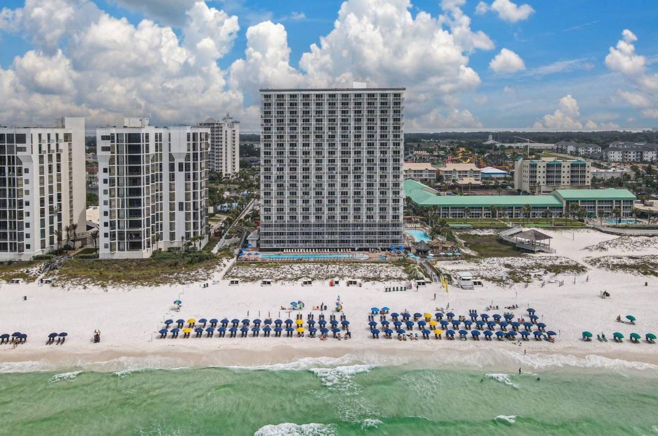 View of the Gulffront facade of Pelican Beach Resort with the beach in front