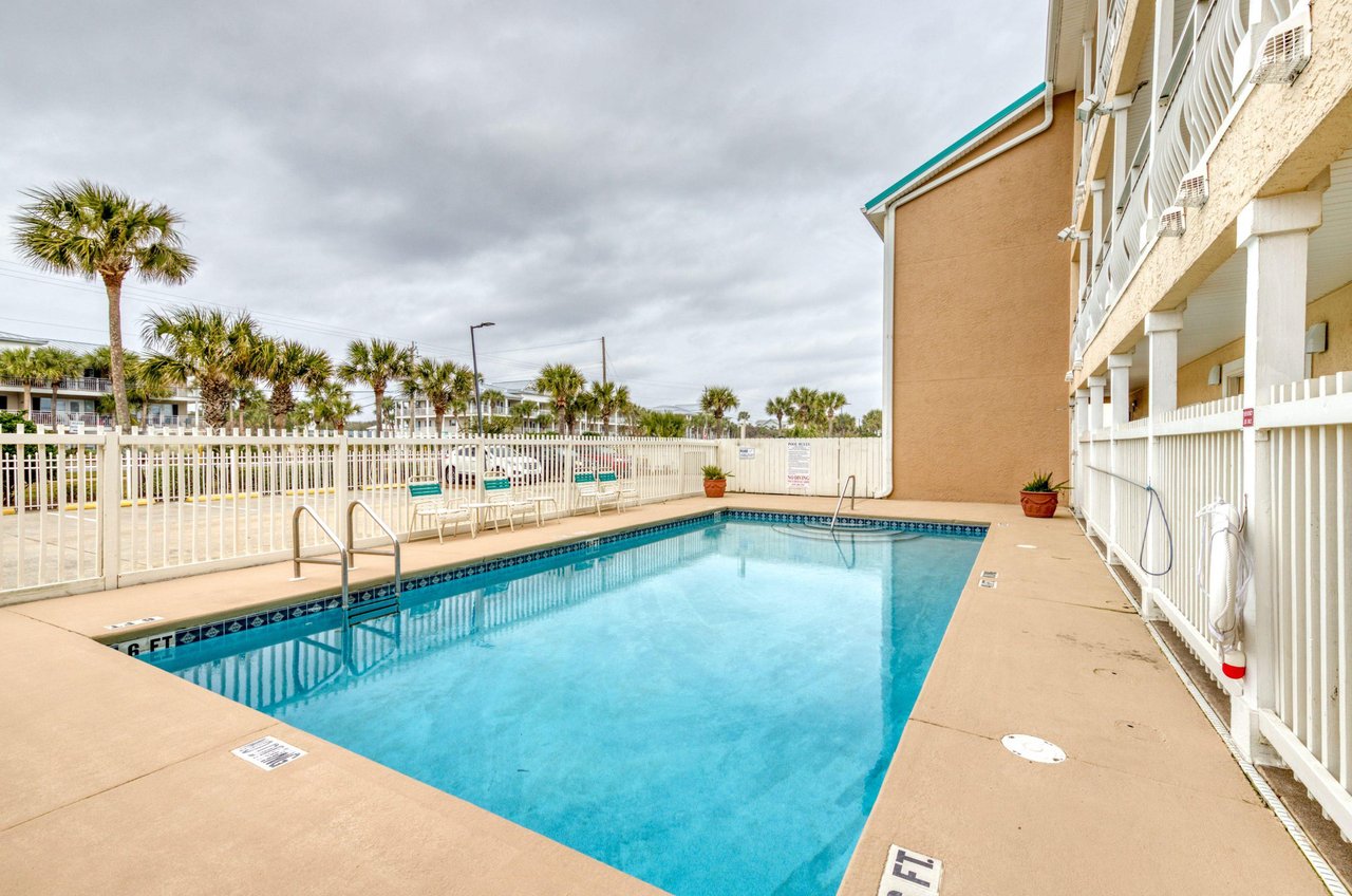 Crystal Sands sparkling swimming pool is surrounded by a fence.