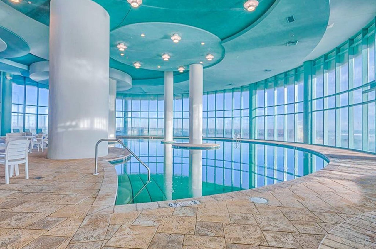 The indoor swimming pool with floor to ceiling windows overlooking the Gulf of Mexico