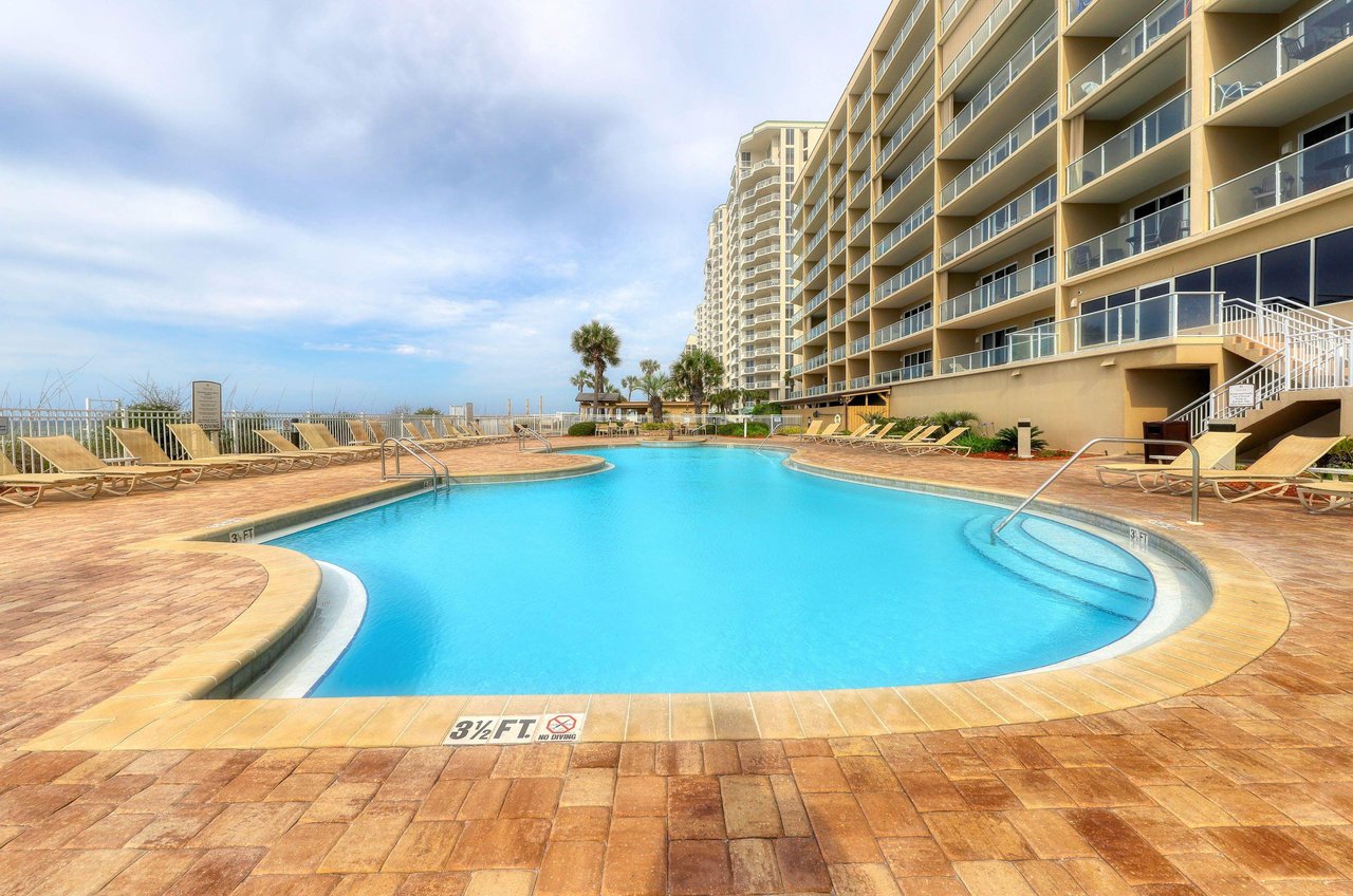 A spacious community pool and sun deck with lots of loungers for relaxing and sunbathing